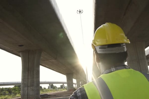 Asian foreman  to check data on construction site of concrete highway bridge